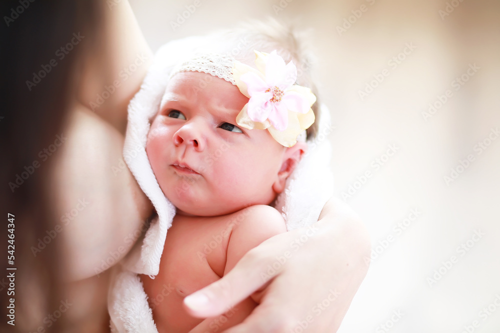 A newborn baby lies in her mother's arms. A beautiful baby of European appearance is sleeping. A newborn baby lies in her mother's arms. A beautiful baby of European appearance is sleeping.