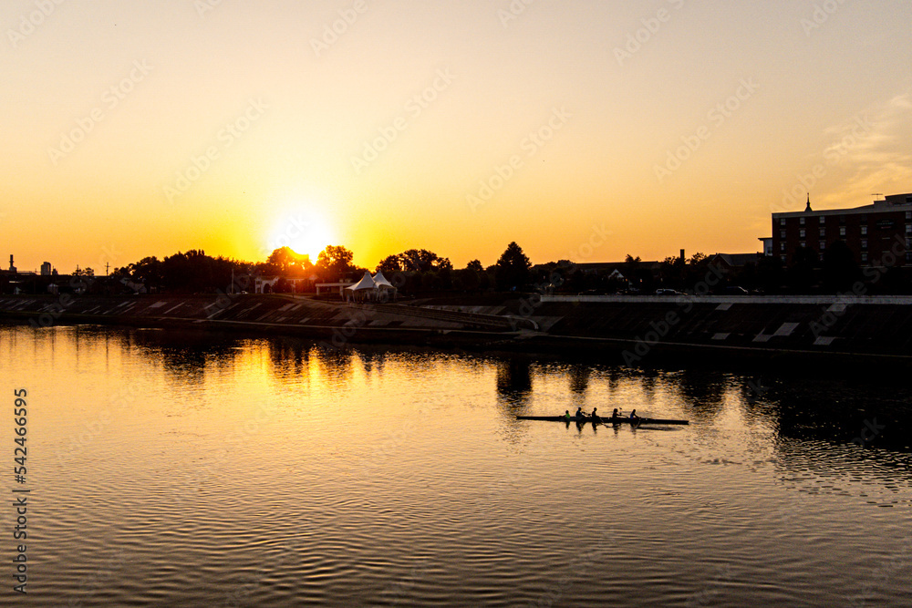 Sunrise Over A River With A Boat