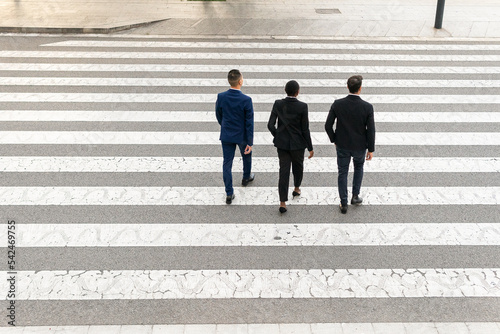 Multiethnic coworkers walking on crosswalk photo