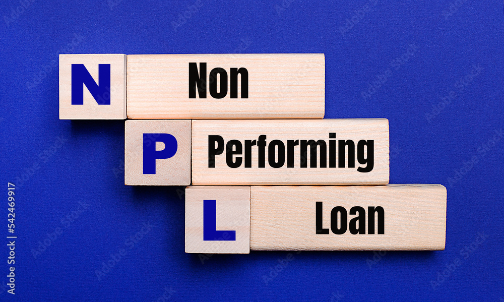 Obraz premium On a bright blue background, light wooden blocks and cubes with the text NPL Non Performing Loan