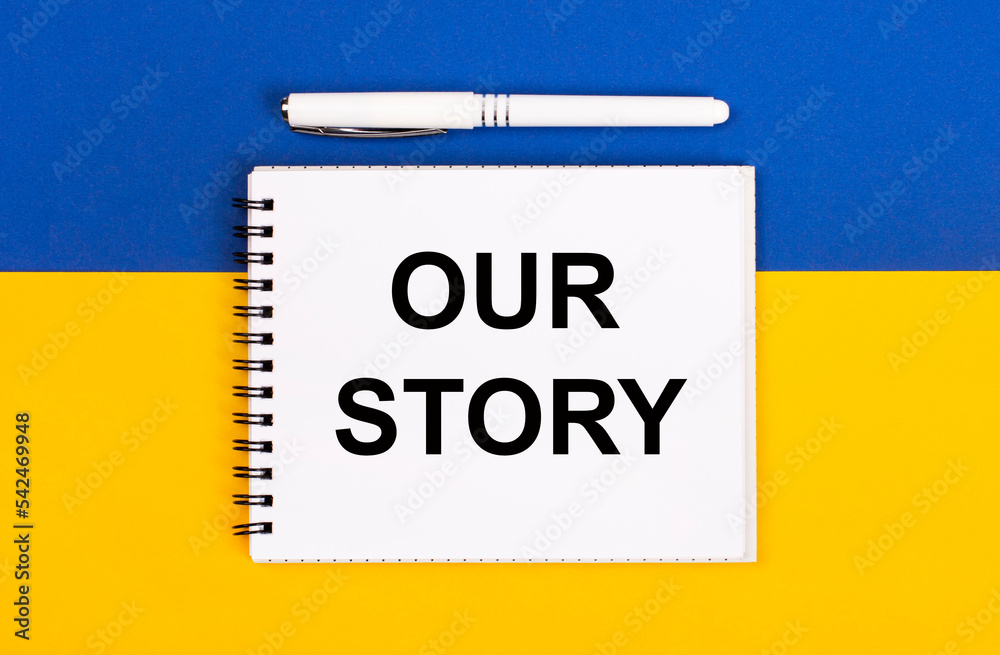 Obraz premium A white notebook with the text OUR STORY and a white pen on a blue and yellow background.
