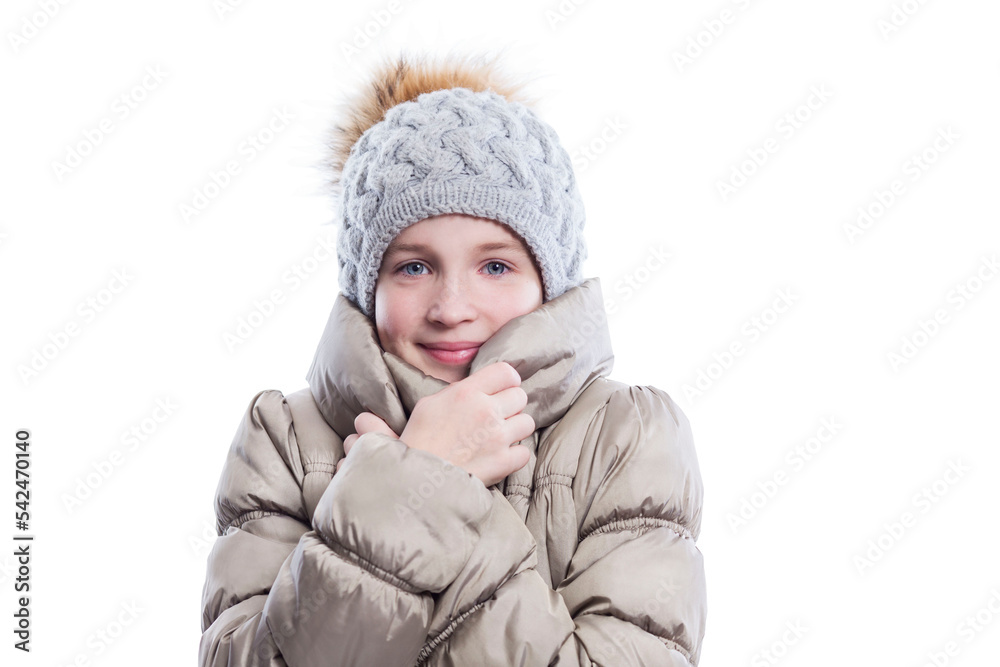Smiling teenage girl in a warm jacket and a knitted hat with a fluffy pompom. Warmth and comfort in the cold season. Isolated on white background. Close-up. Smiling teenage girl in a warm jacket and a knitted hat with a fluffy pompom. Warmth and comfort in the cold season. Isolated on white background. Close-up.
