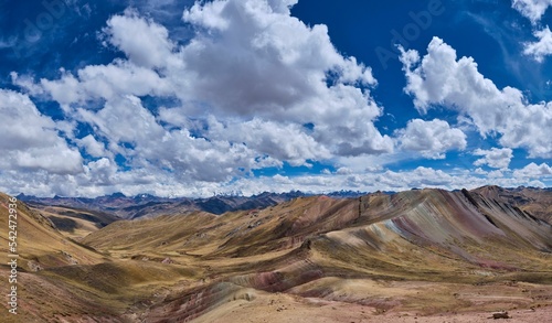 Scenic shot of the Rainbow Mountain under a blue sky with clouds in Peru