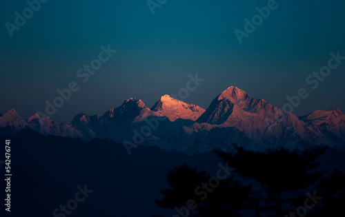 First ray of morning sun on majestic Mt. Everest (the highest peak in the World) of Himalayas. Peaks are Lhotse, Everest (the highlighted one), Makalu and Chomo Lonzo (L to R). Viewed from Sandakphu.