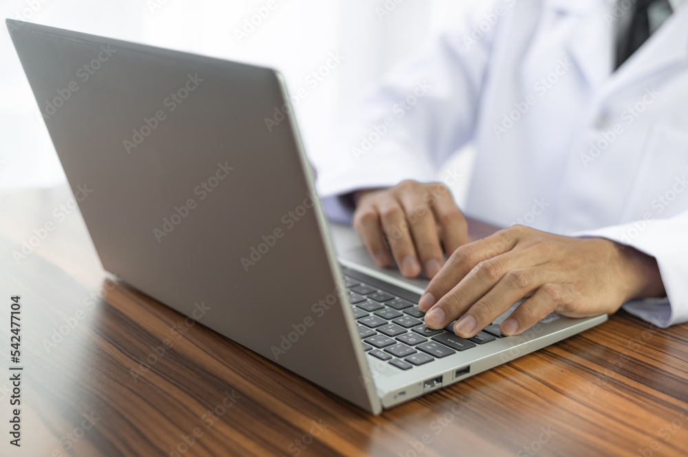 Doctor using computer working in hospital, Doctor using computer checking data patient document, Doctor using computer for health care hospital background Doctor using computer working in hospital, Doctor using computer checking data patient document, Doctor using computer for health care hospital background