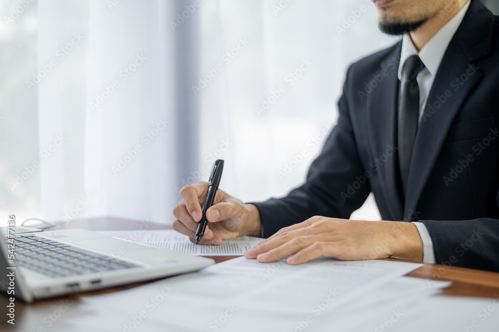 businessman signature document, Signing contract, business agreement, deal concept. Business man signing official contract, formal document with a pen and using laptop computer on table businessman signature document, Signing contract, business agreement, deal concept. Business man signing official contract, formal document with a pen and using laptop computer on table