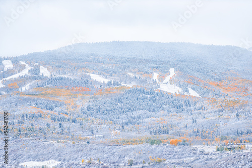 Aspen, Colorado in rocky mountains roaring fork valley from high angle view during autumn season changing into snowy winter with yellow foliage