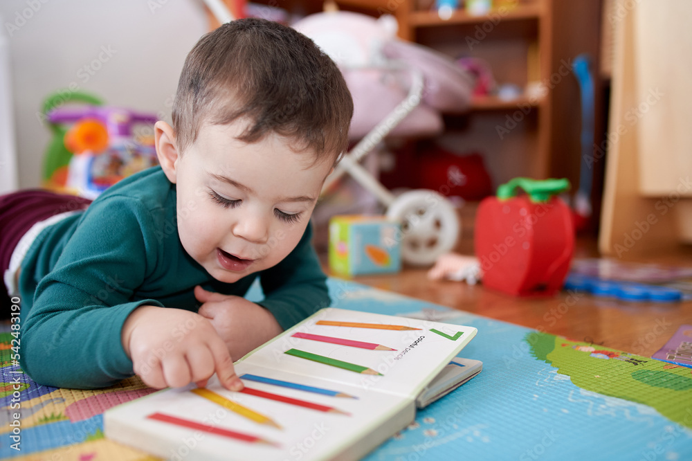 young boy playing and looking at books in his room young boy playing and looking at books in his room