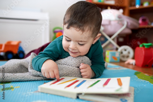 young boy playing and looking at books in his room