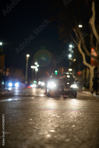 Blurred vehicle front view at night from street view person crossing