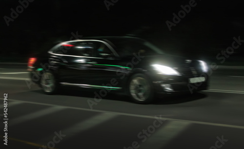 Black car rushes along the night road