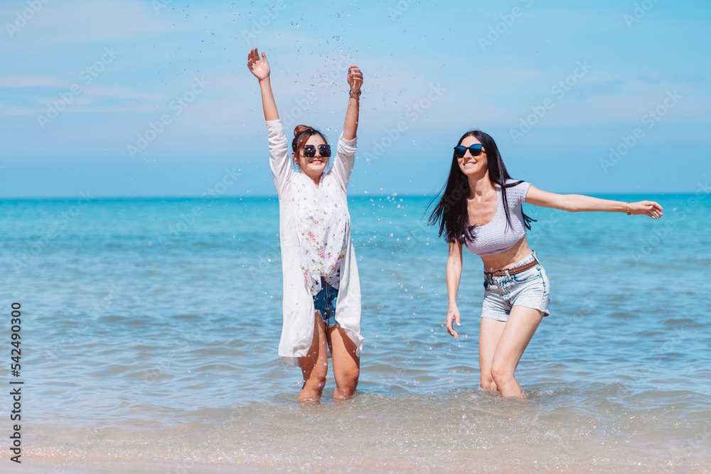 Happy two woman friends enjoying together on the beach. Couple lady are relax on tropical beach feel happy and relax about the summer vacation and having fun. Happy two woman friends enjoying together on the beach. Couple lady are relax on tropical beach feel happy and relax about the summer vacation and having fun.