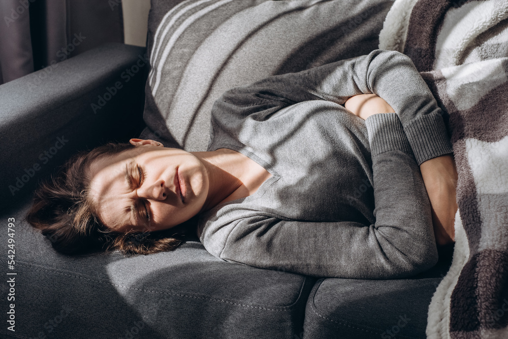 Depressed young caucasian woman lying sofa with her arms around herself, unhappy caucasian female brunette suffering from insomnia depression, psychological problem, concept impotence, asthenia Depressed young caucasian woman lying sofa with her arms around herself, unhappy caucasian female brunette suffering from insomnia depression, psychological problem, concept impotence, asthenia