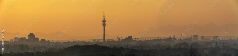 Fototapeta premium Munich Skyline, Panorama München bei Sonnenaufgang mit gelben Saharastaub in der Luft