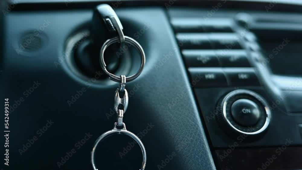 Close up car keys in ignition with music player display board, slow motion Close up car keys in ignition with music player display board, slow motion