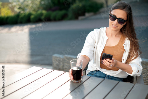 Young woman using smartphone on sunny hotel terrace