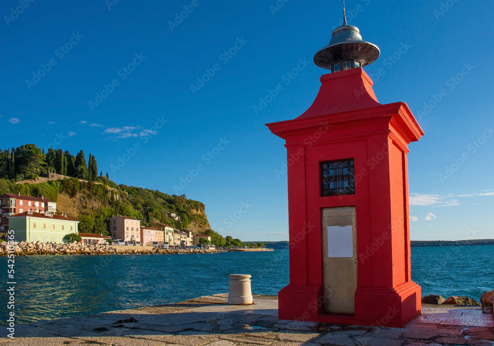 A red lighthouse on the waterfront of the historic medieval town of Piran on the coast of Slovenia
