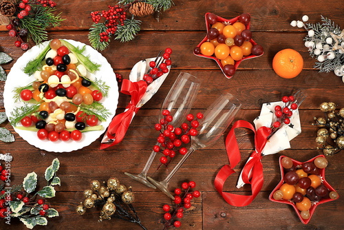 Christmas New Year dishes, for a traditional holiday salad with cheese, olives, tomatoes and grapes, fir branches and decorations, food design idea, selective focus photo