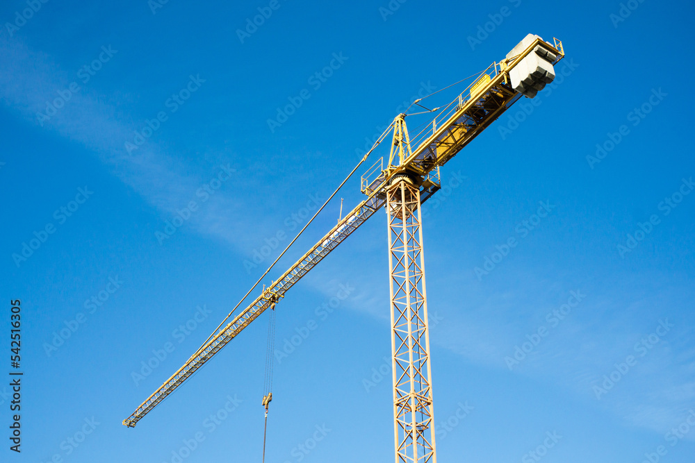 Yellow crane isolated. Heavy machinery equipment isolated on blue sky. Construction site view. Industrial building process. Empty copy space crane background. Building industry view. Yellow crane isolated. Heavy machinery equipment isolated on blue sky. Construction site view. Industrial building process. Empty copy space crane background. Building industry view.