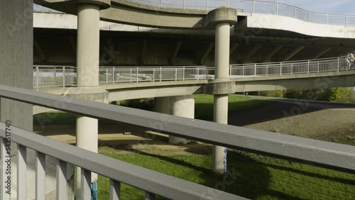 a cyclist rides up a winding road for pedestrians and cyclists to get onto a bridge