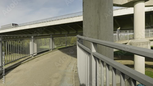 a cyclist rides up a winding road for pedestrians and cyclists to get onto a bridge