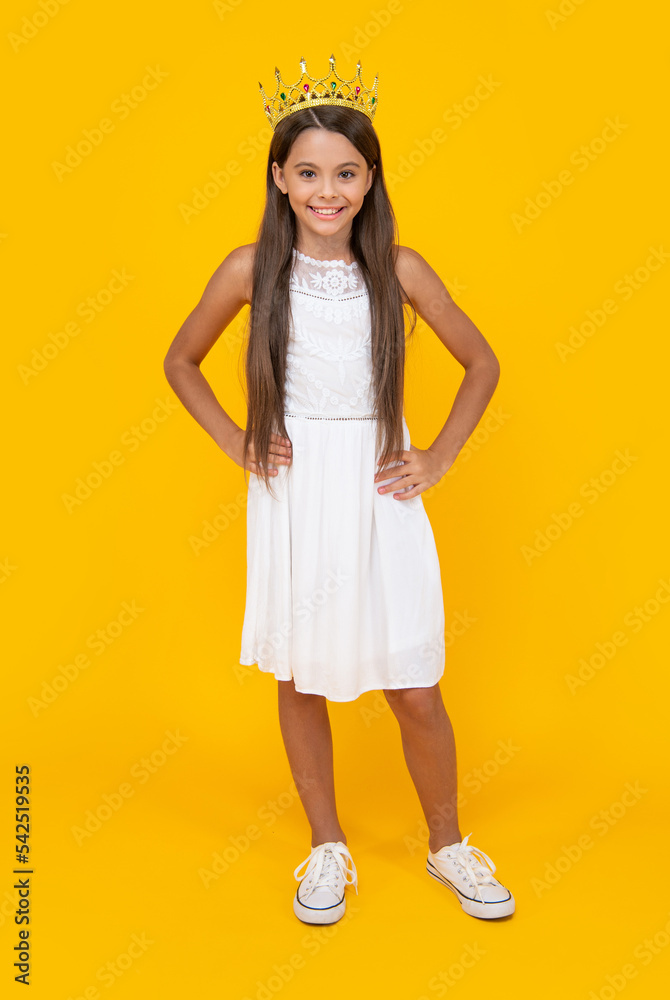cheerful teen kid in crown on yellow background cheerful teen kid in crown on yellow background