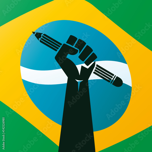 Bandeira do Brasil de fundo com punho levantado segurando lápis representando revolução através da educação. photo