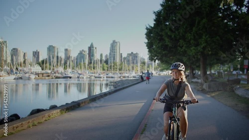 Girl biking along the seawall trail in stanley park, vancouver, british columbia
