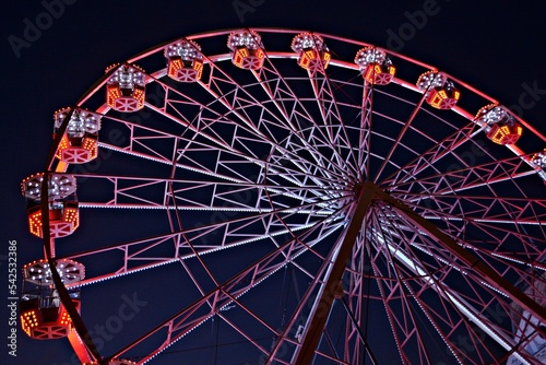 Colorful ferris wheel in a Christmas Market amusement park, with the night lights on