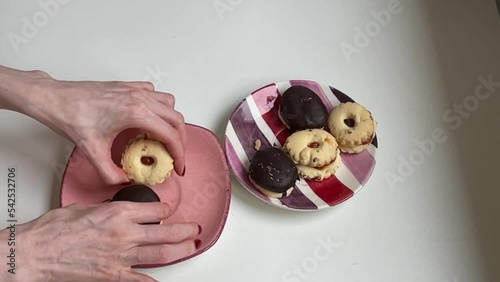 Female hands arranging sweet cookies on ceramic plates