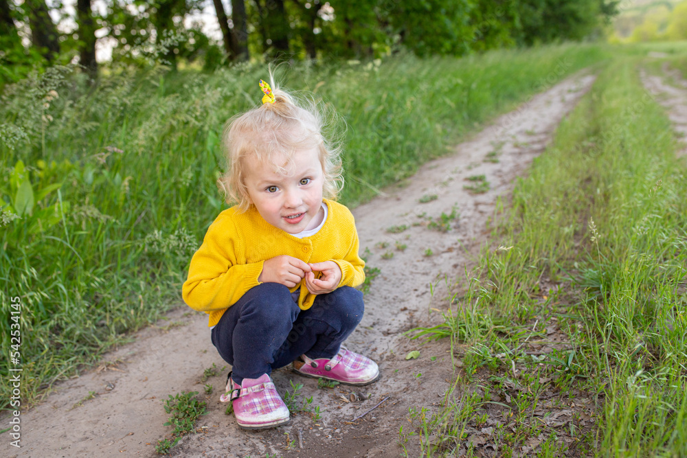 A little girl squatted down on a rural road. A little girl squatted down on a rural road.