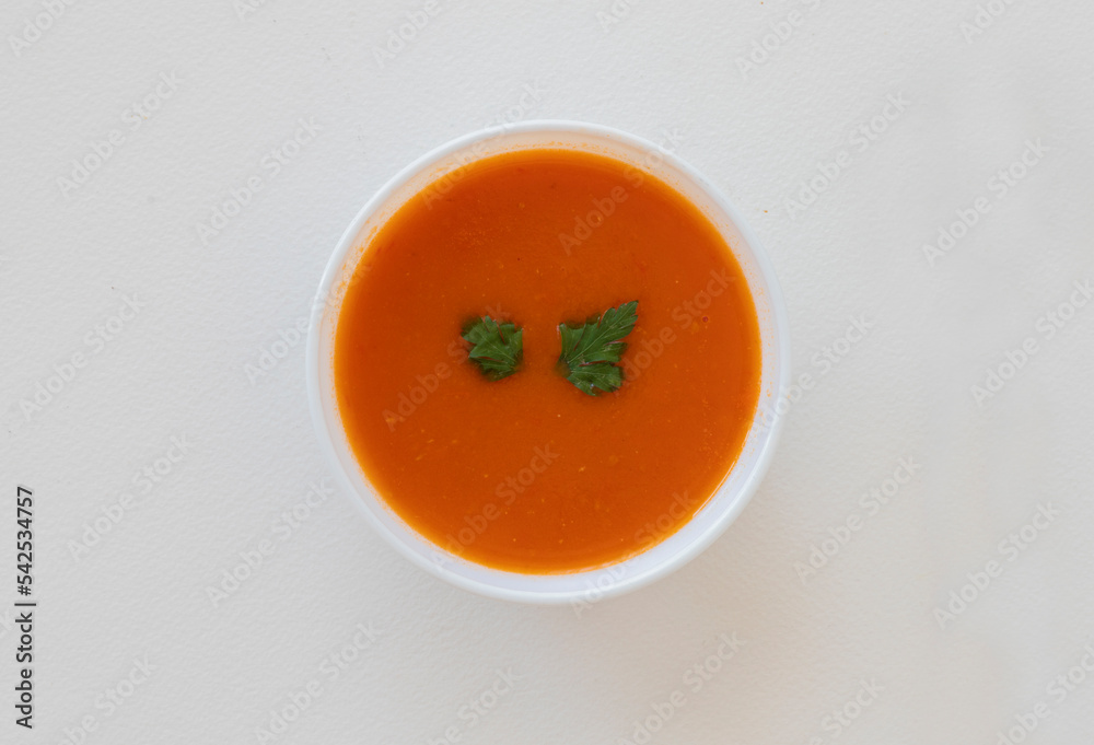 Natural tomato soup in white bowl , top view . Natural tomato soup in white bowl , top view .