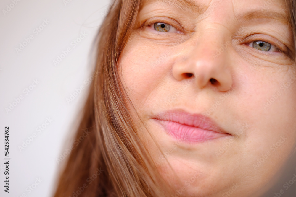 closeup of mature female face, woman 50 years old, slight smile on the lips small wrinkles, concept cosmetic anti-aging procedures, facial massage, mole removal, procedure skincare, selective focus closeup of mature female face, woman 50 years old, slight smile on the lips small wrinkles, concept cosmetic anti-aging procedures, facial massage, mole removal, procedure skincare, selective focus