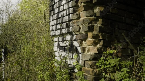 Close-up shot of the ruins of a brick building with white graffiti on the remains of the walls
