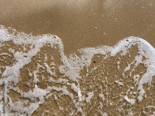 a foamy wave on the sand of the north sea beach