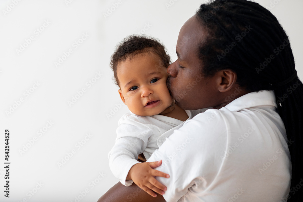 Loving Young Black Dad Holding And Kissing His Adorable Baby Son, Closeup Loving Young Black Dad Holding And Kissing His Adorable Baby Son, Closeup