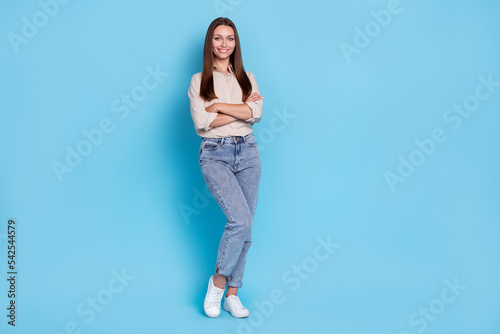 Full length photo of funny millennial lady stand wear grey shirt jeans sneakers isolated on blue color background