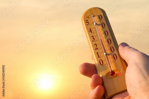 Thermometer for measuring temperature in nature against the background of the sky in the summer hot weather