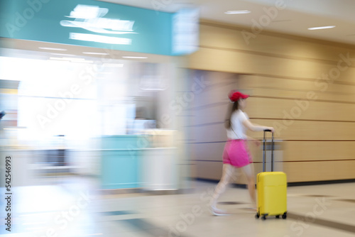 A blurry traveling woman with a suitcase © Cavan