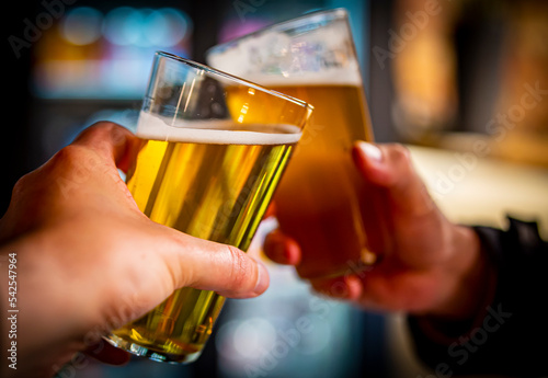 Two friends hands toasting with glasses of craft beer at the pub or bar. taproom