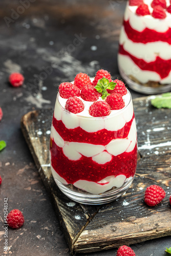 Scottish dessert whipped cream, roasted oatmeal and raspberries in jar. banner, menu, recipe place for text, top view photo