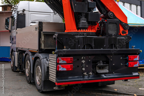 Back view of a car with a crane standing on a city street.