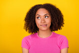Photo of minded young lady biting lips look interested empty space decide isolated on yellow color background
