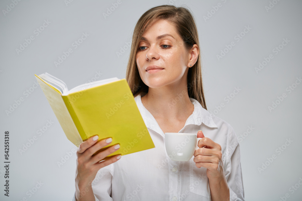 Student girl holding open yellow book and white coffee cup. Isolated advertising portrait. Student girl holding open yellow book and white coffee cup. Isolated advertising portrait.