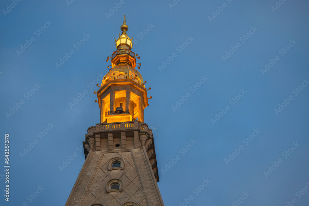 Beautiful close up view of top of big bell tower on blue sky background. USA. 
