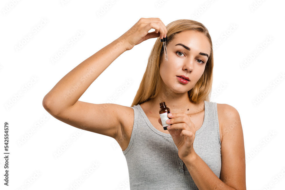 Young woman with face serum pipette for acne treatment and wrinkle smoothing. Girl applies face serum to her face with pipette on white background. Young woman with face serum pipette for acne treatment and wrinkle smoothing. Girl applies face serum to her face with pipette on white background.