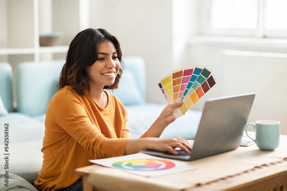 Arab Female Freelance Graphic Designer Working With Laptop And Color Swatches Arab Female Freelance Graphic Designer Working With Laptop And Color Swatches
