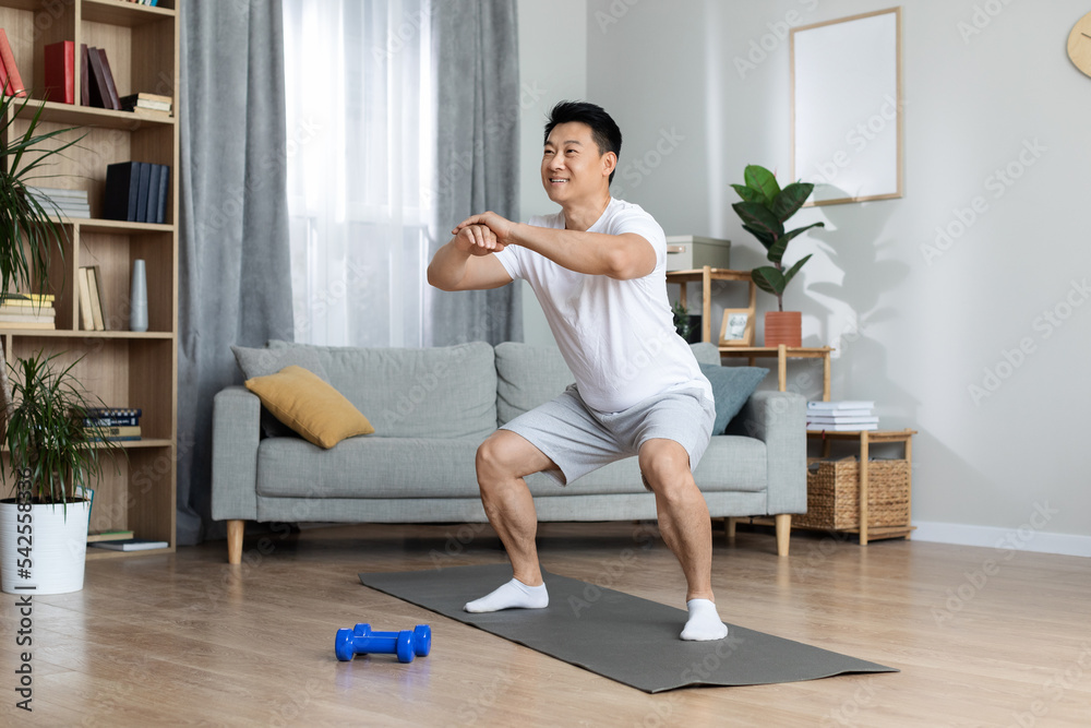 Happy chinese man having workout at home Happy chinese man having workout at home