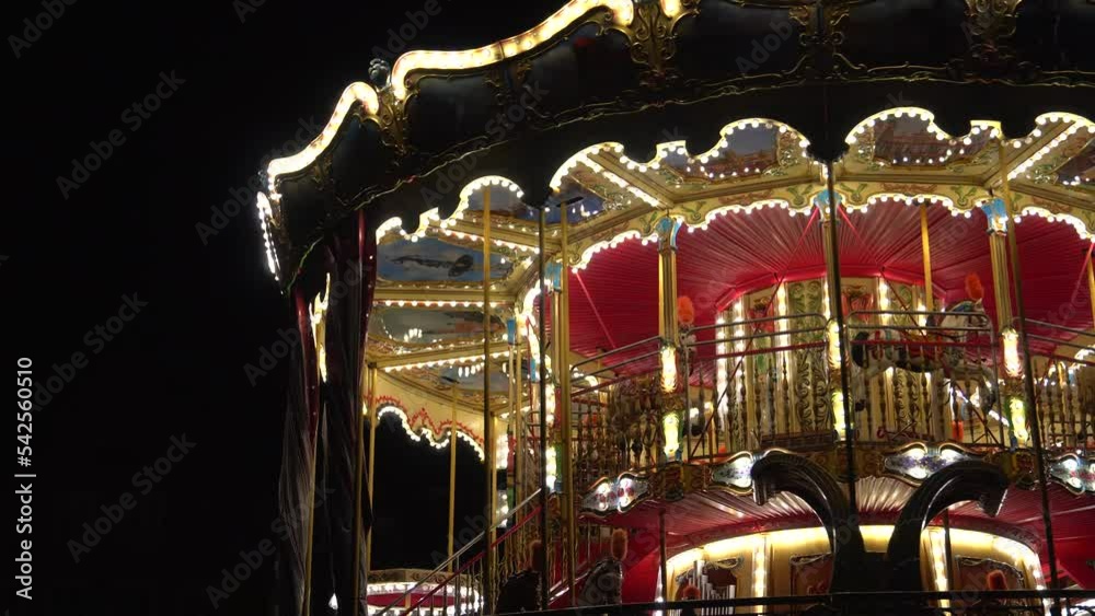 Beautiful illuminated carousel details during the round of the Christmas market. Vintage colorful carousel