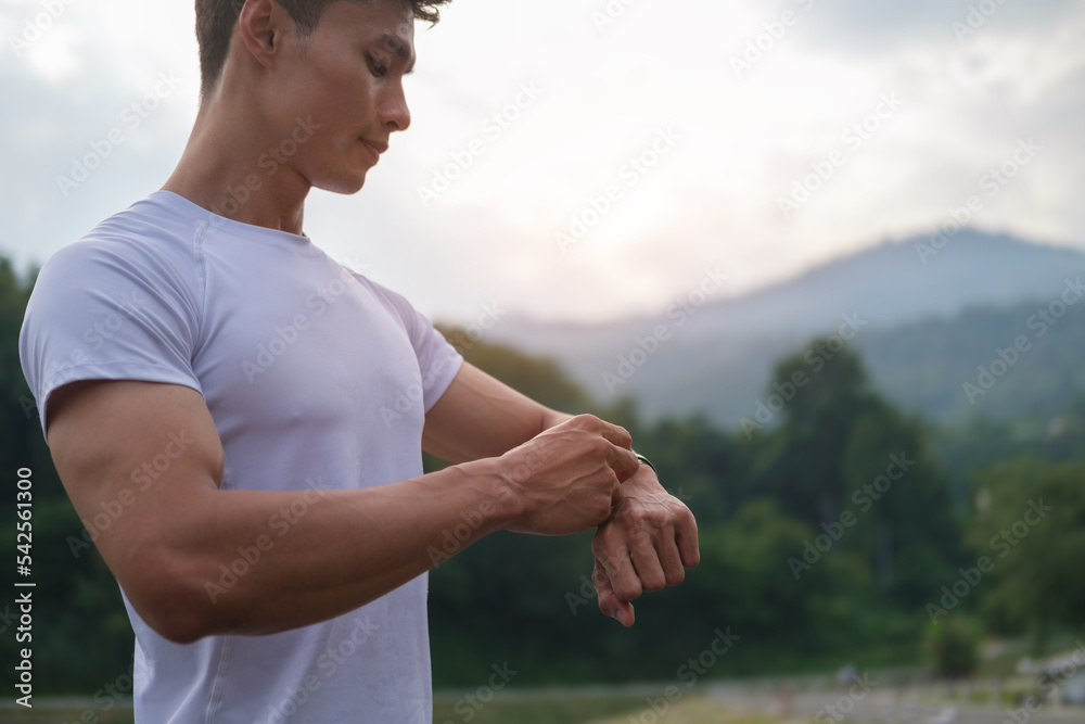 Sportsman resting and checking performance, heart rate pulse trace on his smartwatch. Sport, exercise and fitness outdoors in nature. Sportsman resting and checking performance, heart rate pulse trace on his smartwatch. Sport, exercise and fitness outdoors in nature.